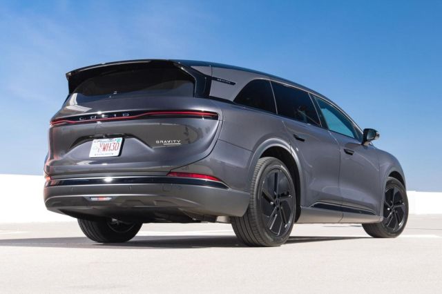 A sleek gray Lucid Gravity SUV parked against a clear blue sky.