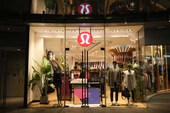 A storefront display of a clothing store featuring mannequins and a large logo above the entrance.