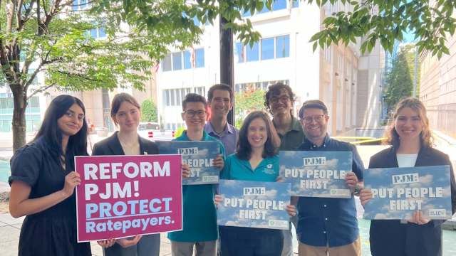 Activists holding signs advocating for PJM ratepayer protection.
