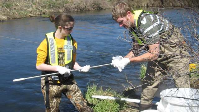 Two USGS scientists taking samples from a river.