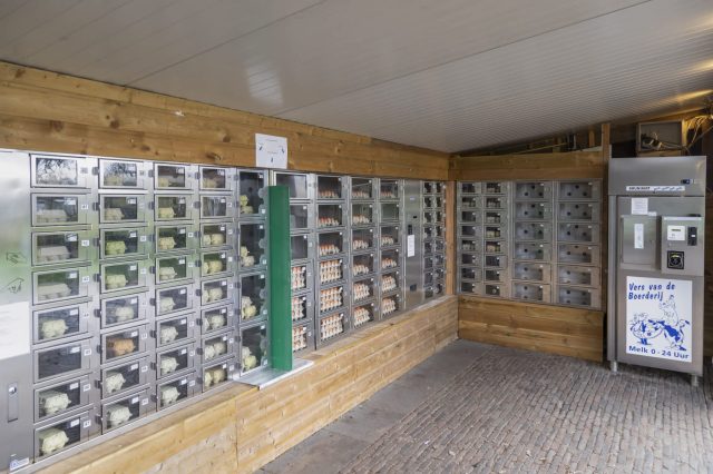 A vending machine area featuring dispensers for eggs and dairy products in a wooden structure.