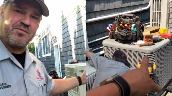 A technician gestures toward an air conditioning unit while another technician works on it outside a house.