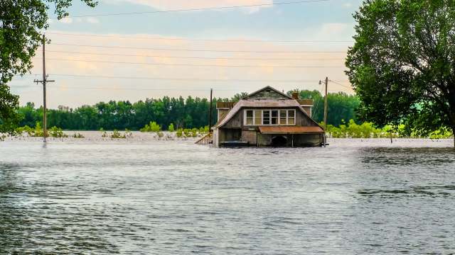 A house partially submerged in floodwaters.