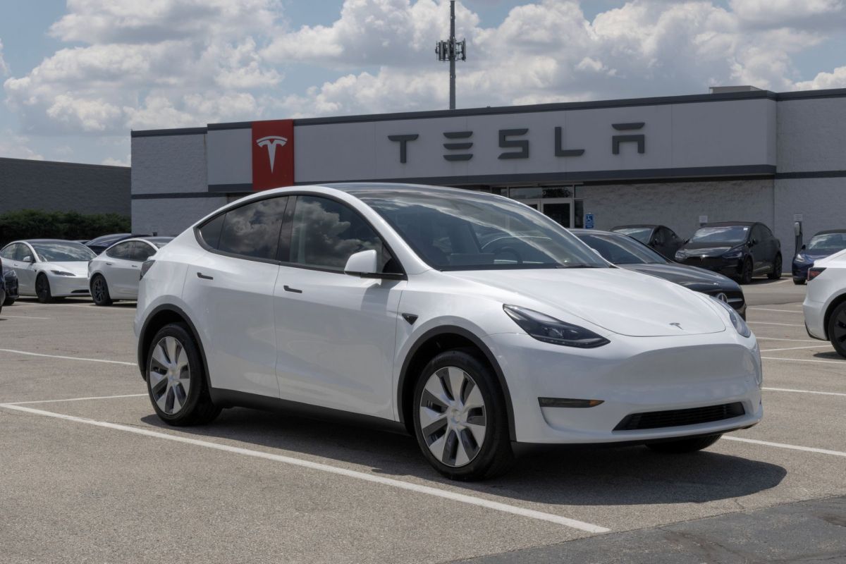 A Model Y in front of a Tesla dealership.