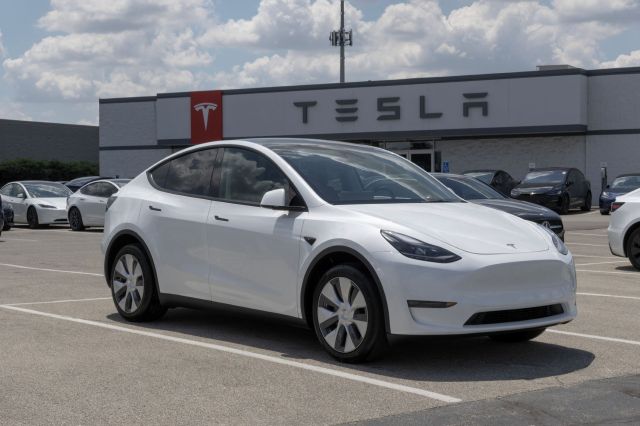 A Model Y in front of a Tesla dealership.