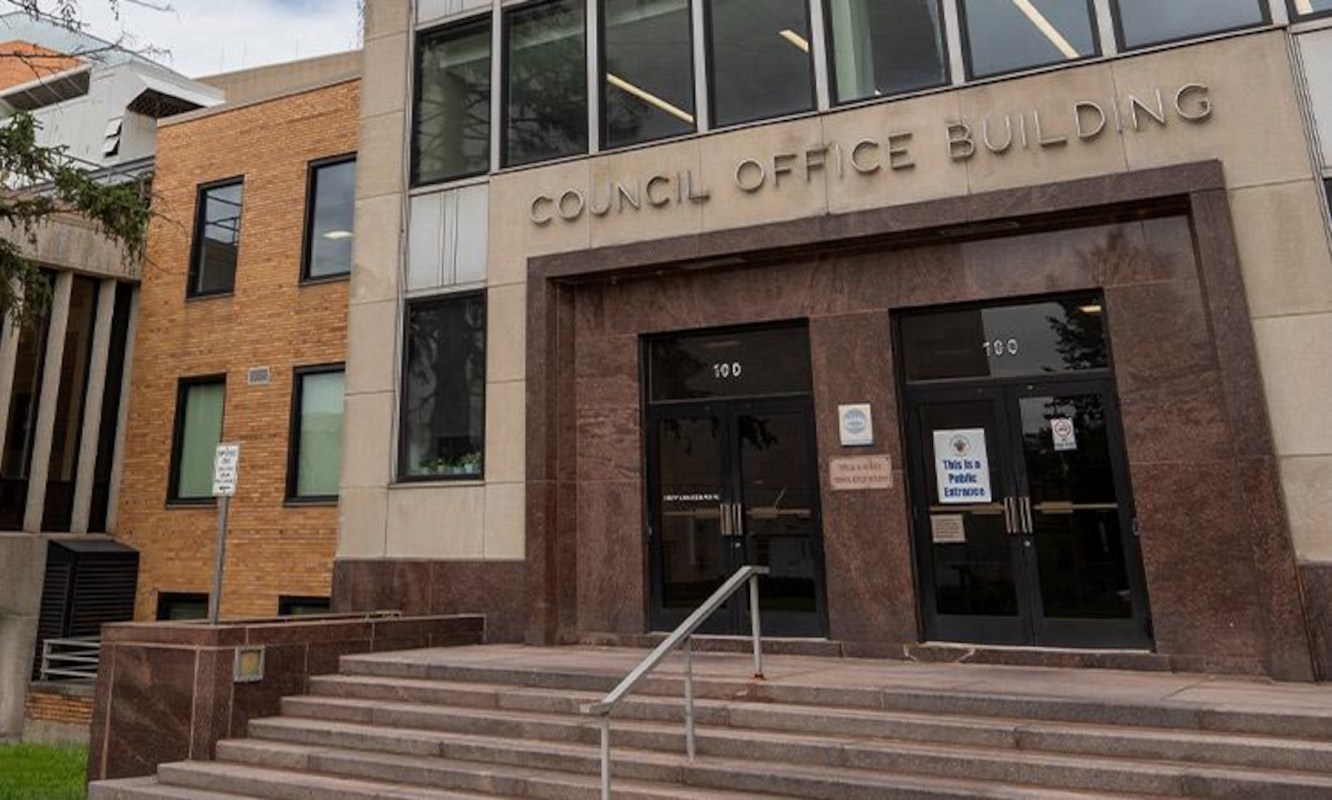The entrance of a council office building with steps and a sign indicating public entrance.