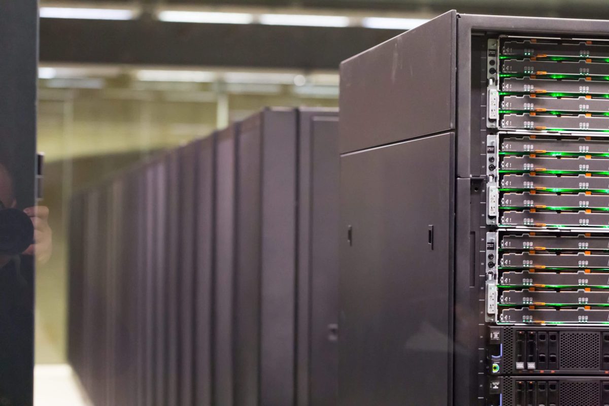 A row of sleek black server racks with illuminated hard drive bays in a modern data center.