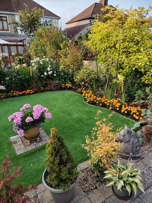 Flower beds surrounding grass patch.