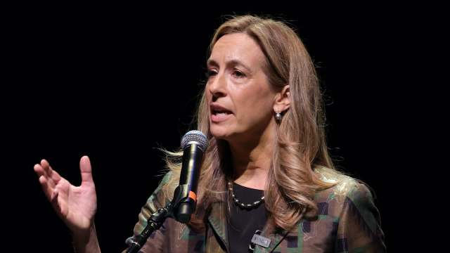 Gov. Mikie Sherrill speaks passionately into a microphone on stage, gesturing with her hand.