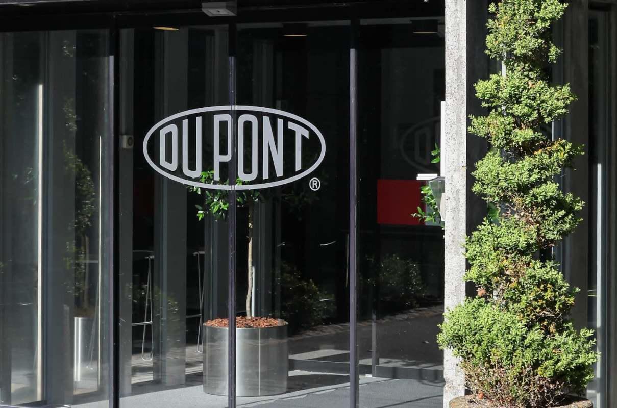 A glass entrance featuring the DuPont logo and a neatly trimmed green plant in a planter.