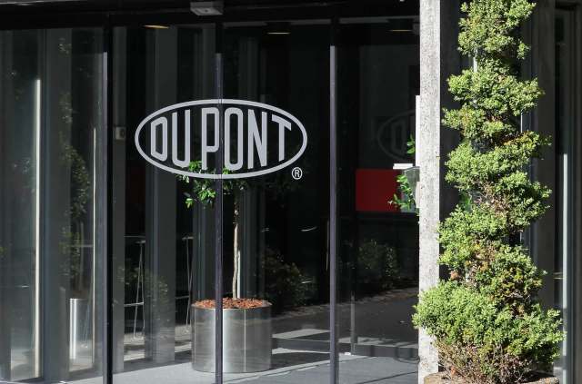 A glass entrance featuring the DuPont logo and a neatly trimmed green plant in a planter.