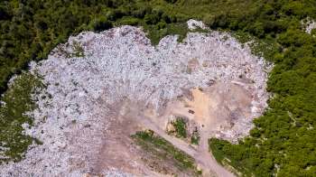 An aerial view of a landfill surrounded by trees.