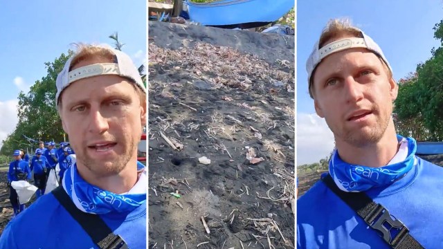 A man talks about beach cleanup efforts with volunteers in the background.