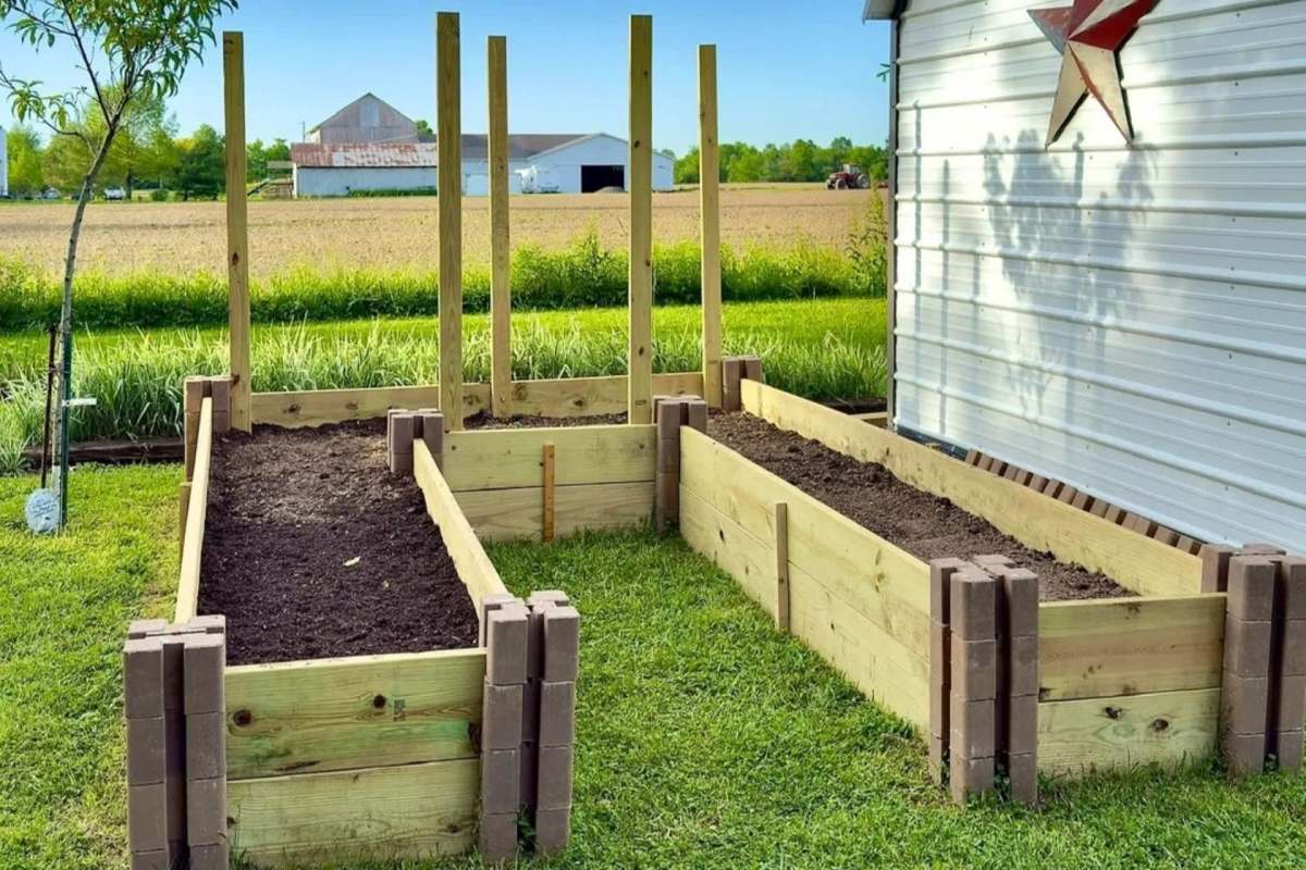 U-shaped garden bed with dirt in it on a bright sunny day with mountains in the background