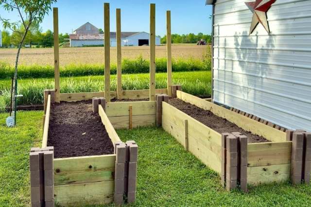 U-shaped garden bed with dirt in it on a bright sunny day with mountains in the background