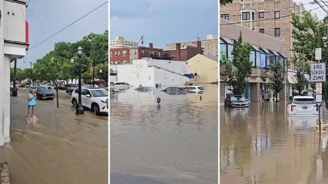 A flooded street with submerged cars, a pedestrian wading through water, and buildings in the background.
