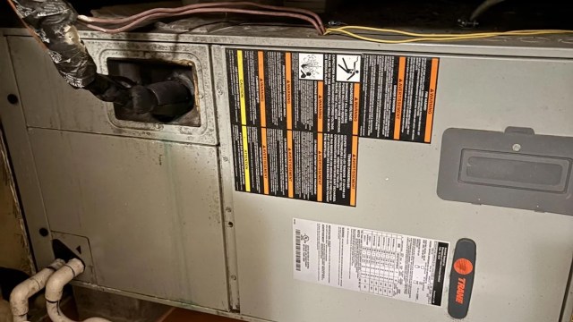 A close-up view of a heating unit with warning labels and technical specifications visible on the side.