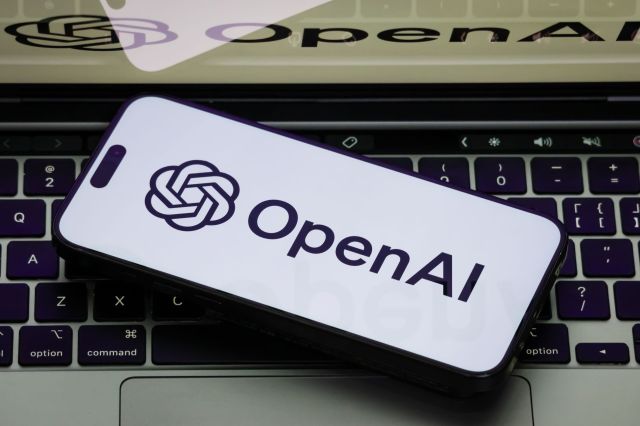 A smartphone displaying the OpenAI logo on a laptop keyboard.
