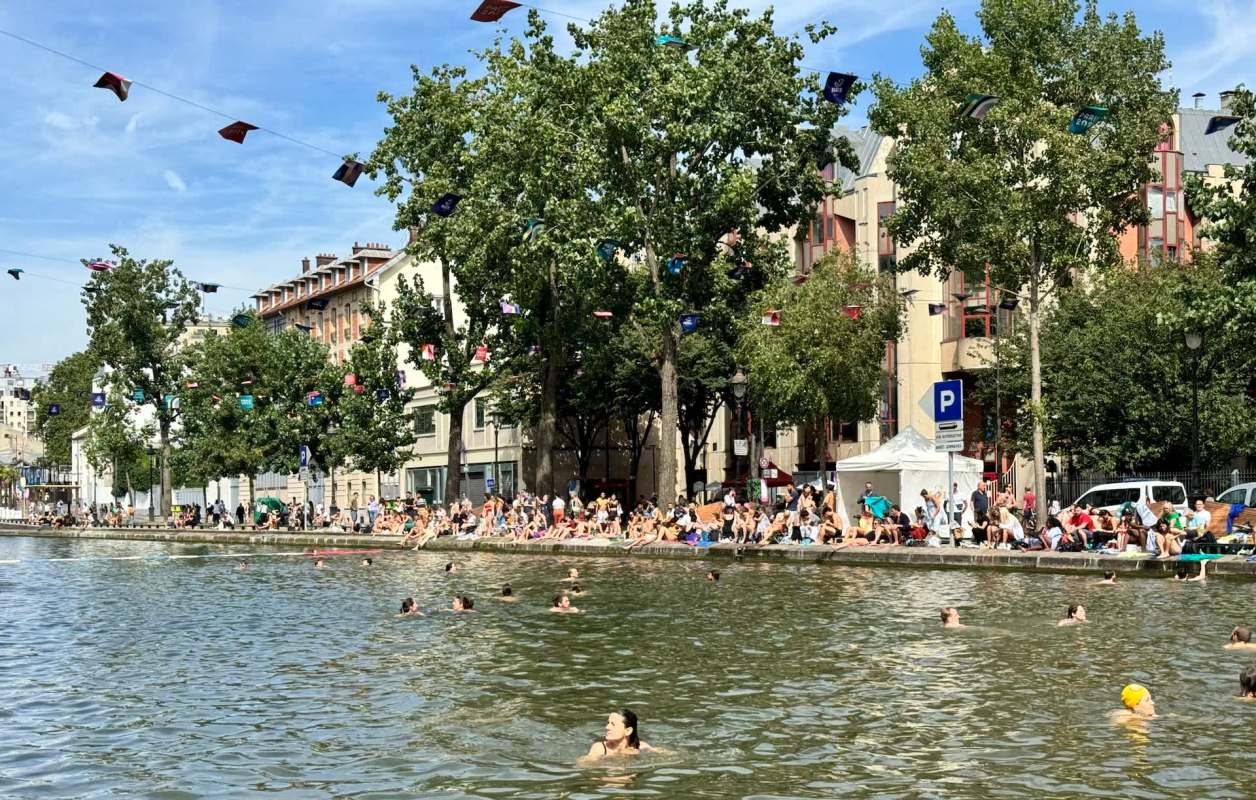 People swimming at a crowded canal in Paris.