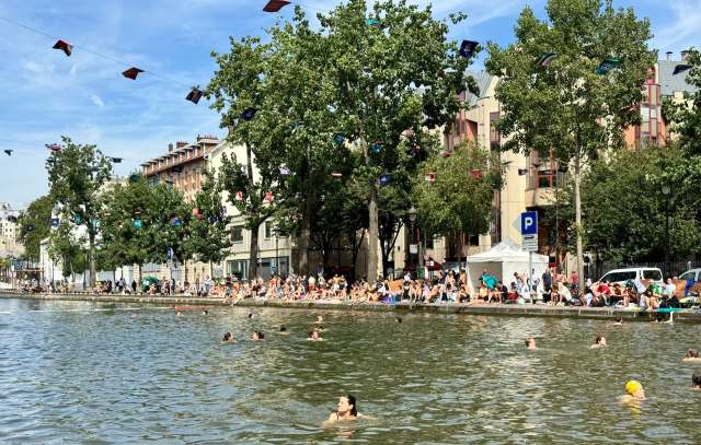 People swimming at a crowded canal in Paris.
