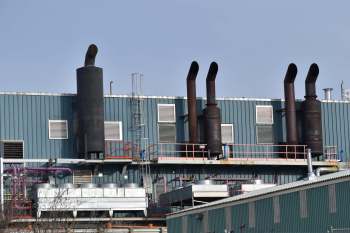 An industrial building with a row of exhaust stacks.
