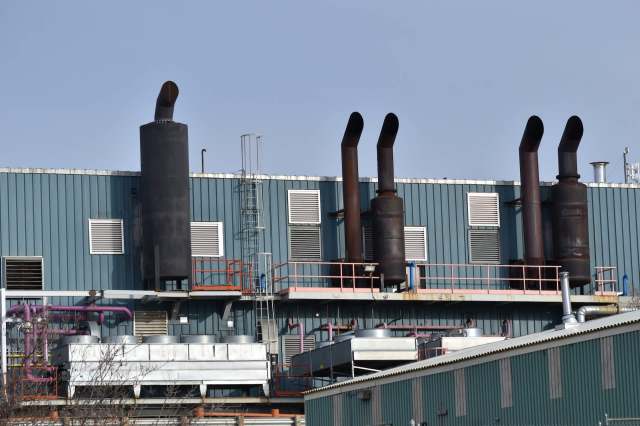 An industrial building with a row of exhaust stacks.