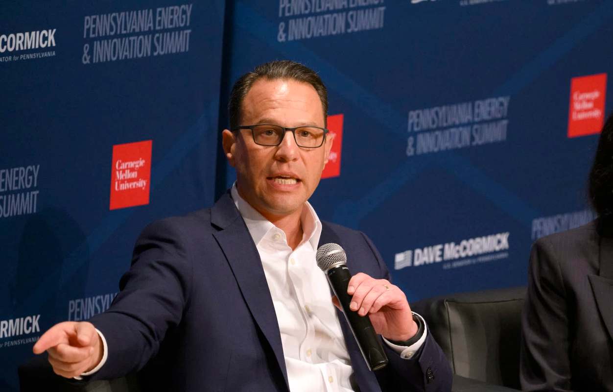 Pennsylvania Gov. Josh Shapiro, wearing glasses, speaks into a microphone at the Pennsylvania Energy and Innovation Summit event.