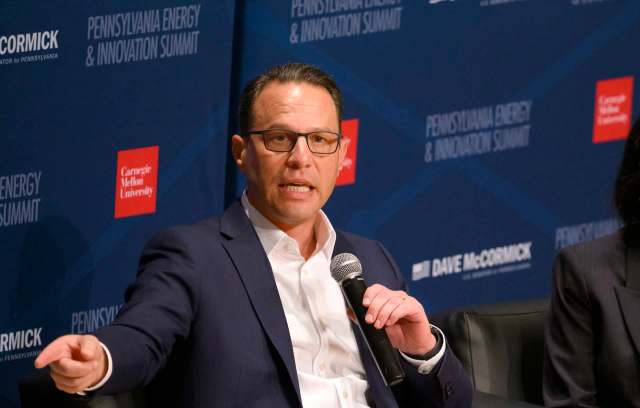 Pennsylvania Gov. Josh Shapiro, wearing glasses, speaks into a microphone at the Pennsylvania Energy and Innovation Summit event.