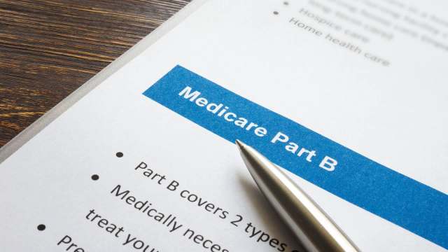 A close-up of a document titled "Medicare Part B" with a silver pen resting on it.