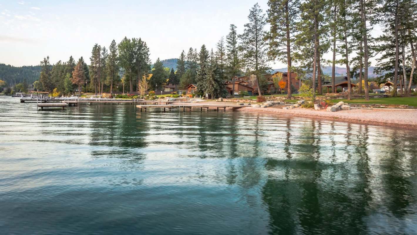 A lakeside view with docks, trees, and houses along the shore.