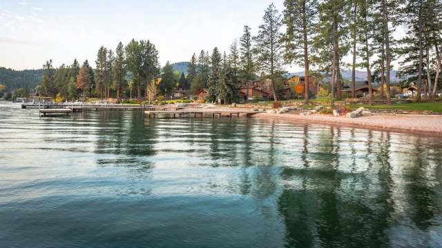 A lakeside view with docks, trees, and houses along the shore.