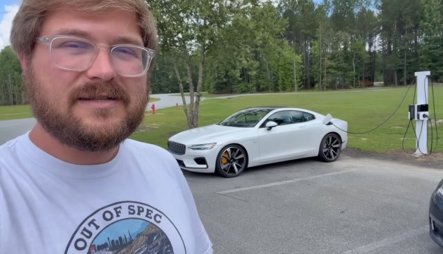 Kyle Conner in front of a white electric car at a charging station.