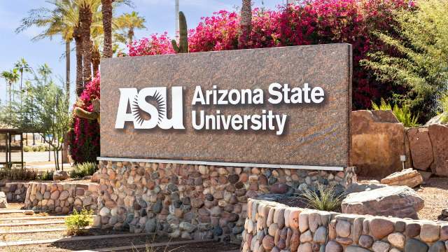 A sign for Arizona State University features the university's abbreviation and name amidst desert landscaping.