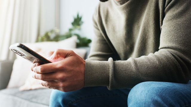 A person sitting down while on their phone.