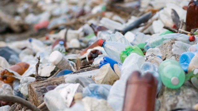 A cluttered beach covered in various plastic bottles and debris.