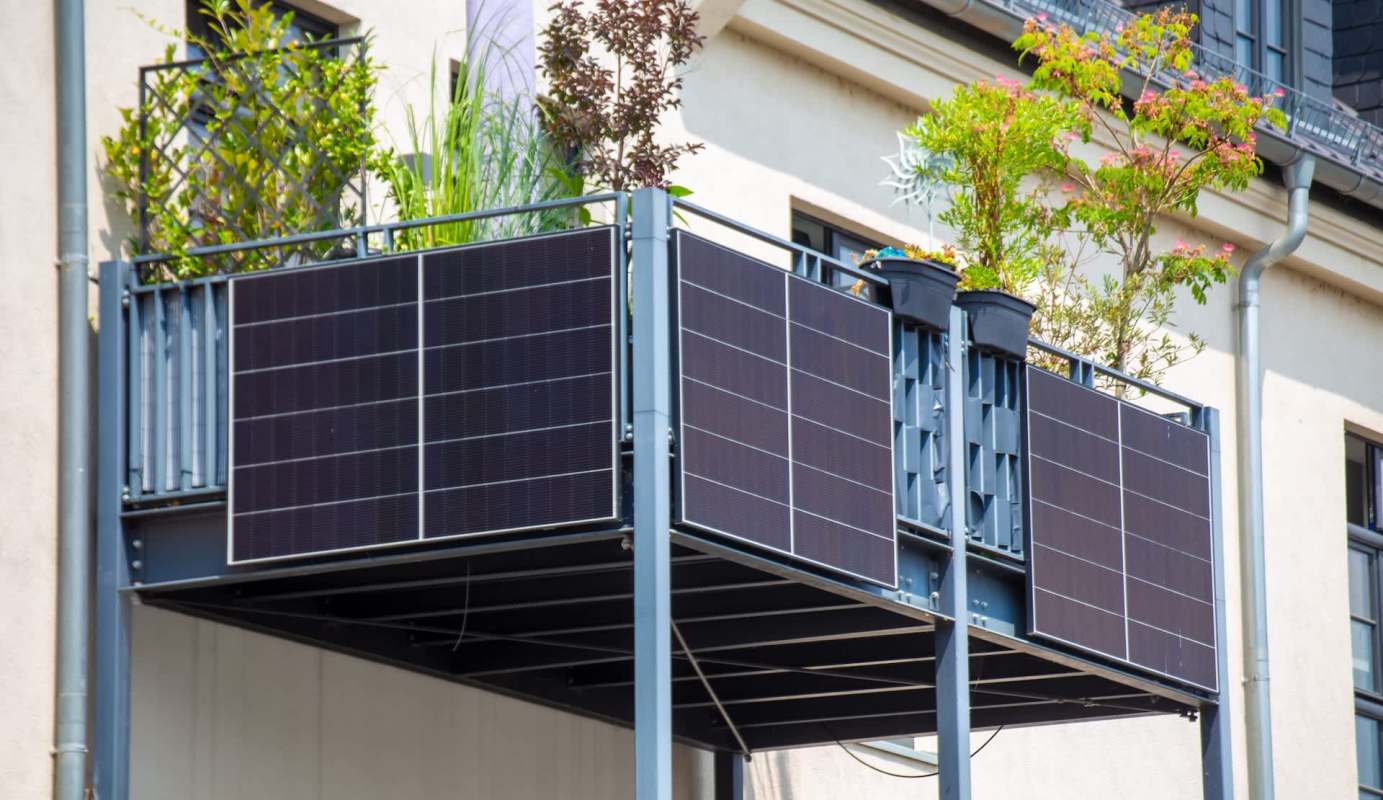 A balcony with solar panels and potted plants, showcasing urban green living.