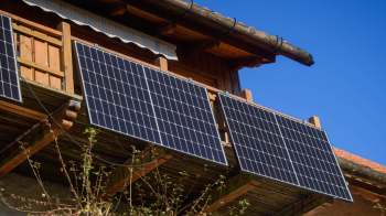 Solar panels mounted on a wooden balcony.