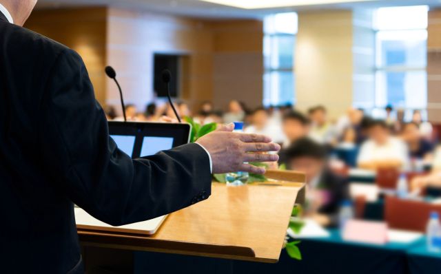 A person speaking at a podium.