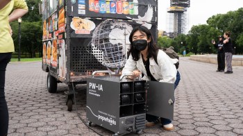 A person posing with an inverter adapter for a clean-powered food cart.