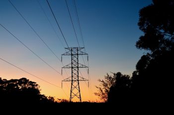 A transmission tower silhouetted at sunset.