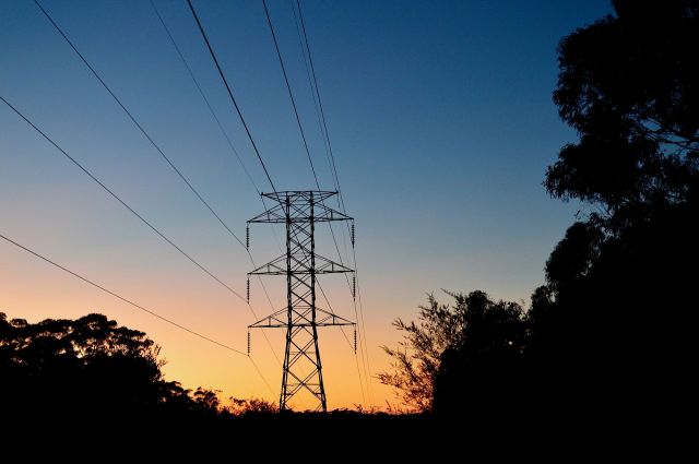 A transmission tower silhouetted at sunset.