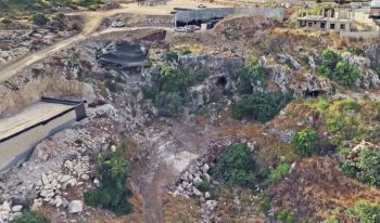 An aerial view of a rocky landscape with construction sites and vegetation in the foreground.