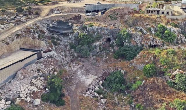 An aerial view of a rocky landscape with construction sites and vegetation in the foreground.