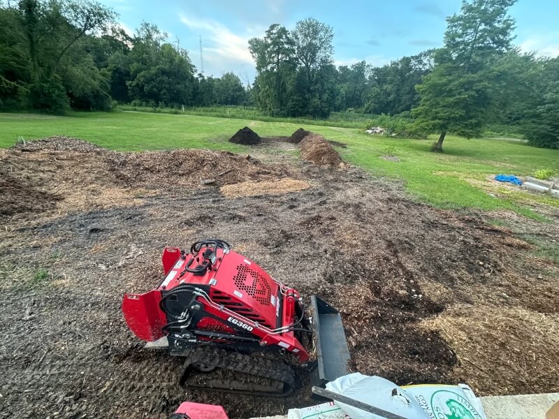 A skid steer on dug up soil.