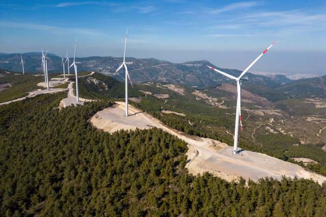 A wind farm with turbines on a hillside.