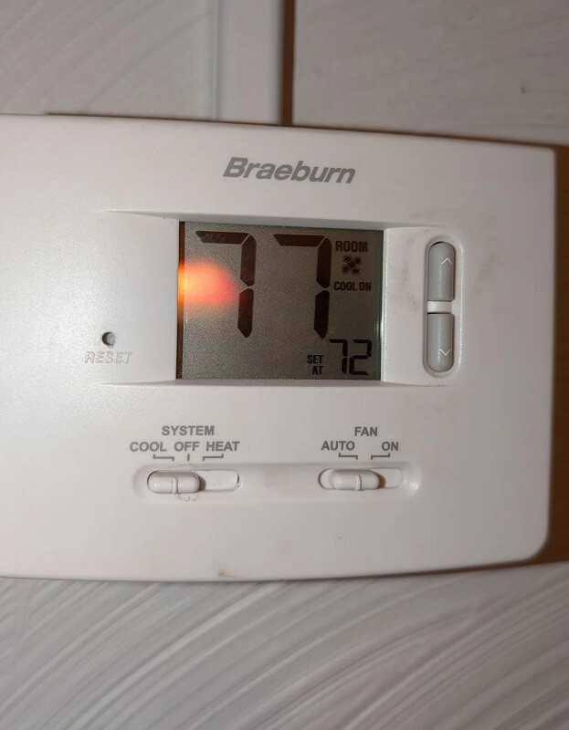 A dirty air filter with a grid pattern, mounted in a ventilation system.