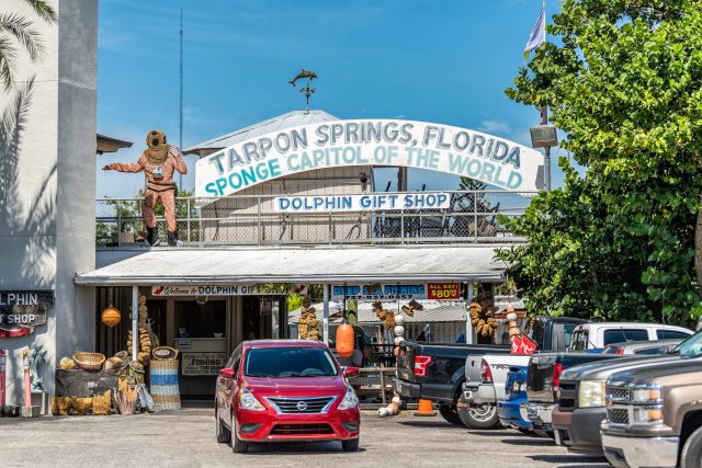 A colorful gift shop in Tarpon Springs, Florida, featuring a diver statue and sponges on display.
