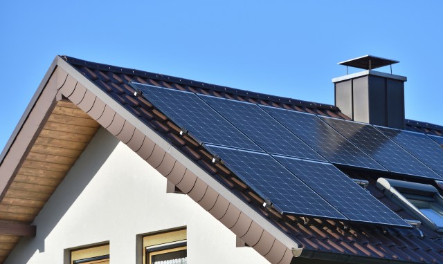 A rooftop with solar panels installed under a clear blue sky.