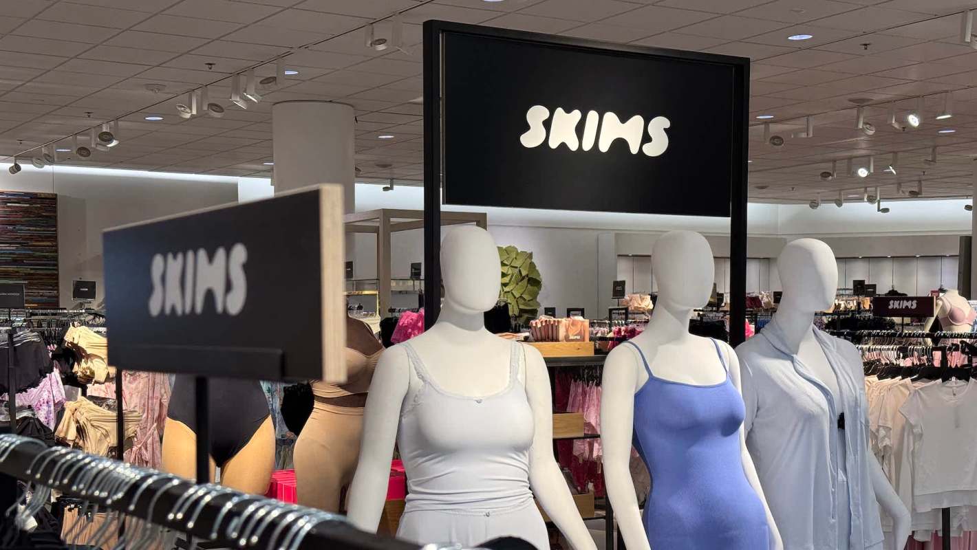 A SKIMS display featuring mannequins dressed in various clothing items in a retail store.