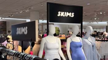 A SKIMS display featuring mannequins dressed in various clothing items in a retail store.